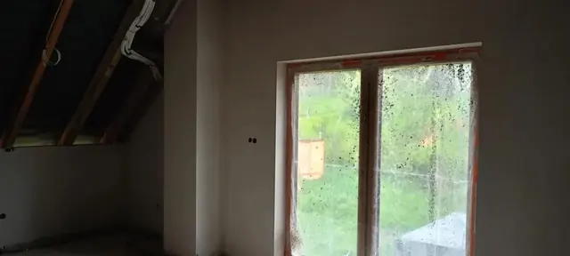 Tynki ścian na poddaszu przy skosie dachu i dużym oknie — Stara Wieś