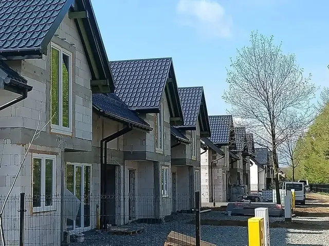 Rząd budowanych domów jednorodzinnych z dachami z ciemnej dachówki i zamontowaną stolarką — Krosno